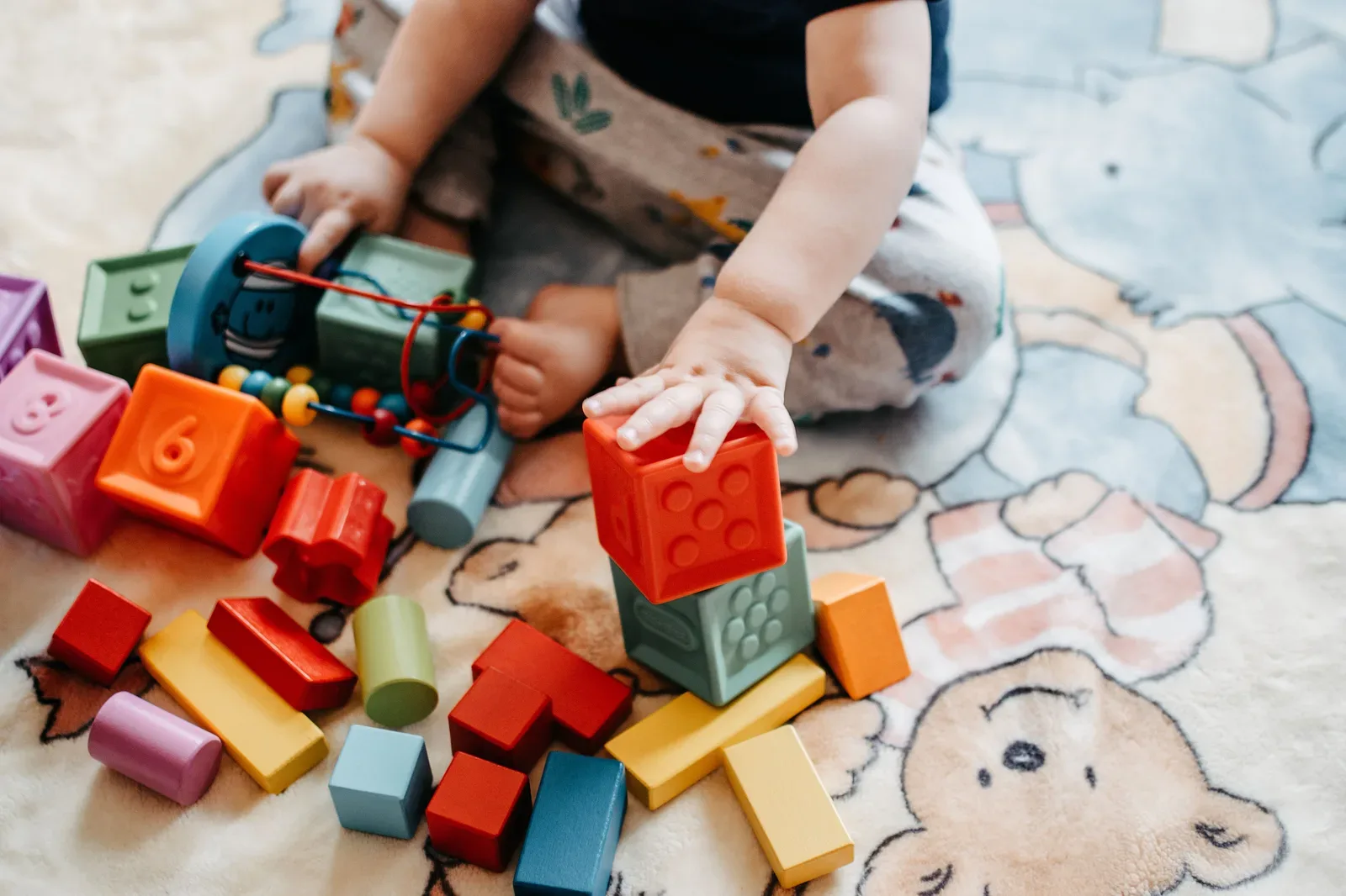 Child building with colorful blocks, representing hands-on creative play