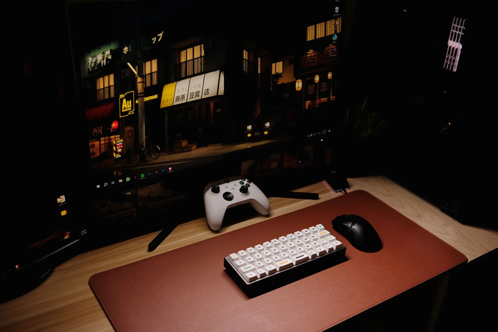 A gaming desk setup showing a keyboard, mouse, and controller side by side